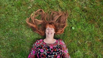 Lachende vrouw al liggend in het gras