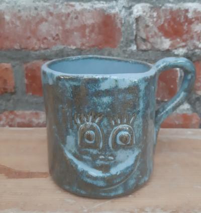 Koffietas in klei , blauwe glazuur met een smiley 