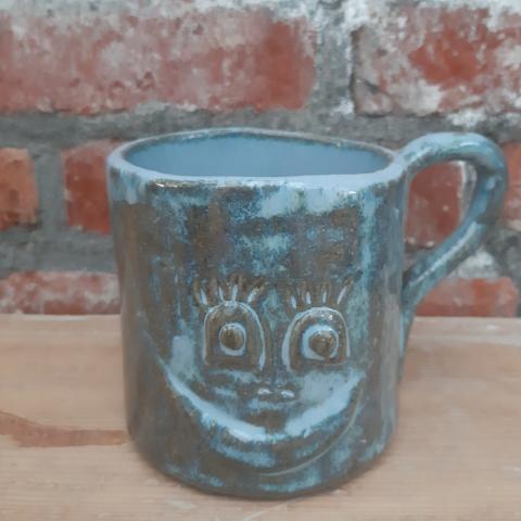 Koffietas in klei , blauwe glazuur met een smiley 